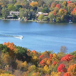 Speed boat on a river surrounded by fall foliage