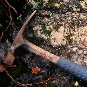 Rock hammer against a stone background