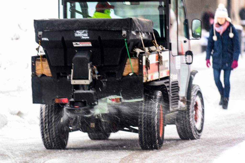 The grounds crew works to remove snow and ice from a campus sidewalk at the University of Wisconsin–Madison.  