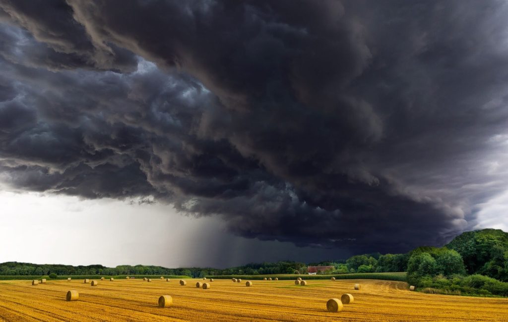 Storm clouds approaching hay field