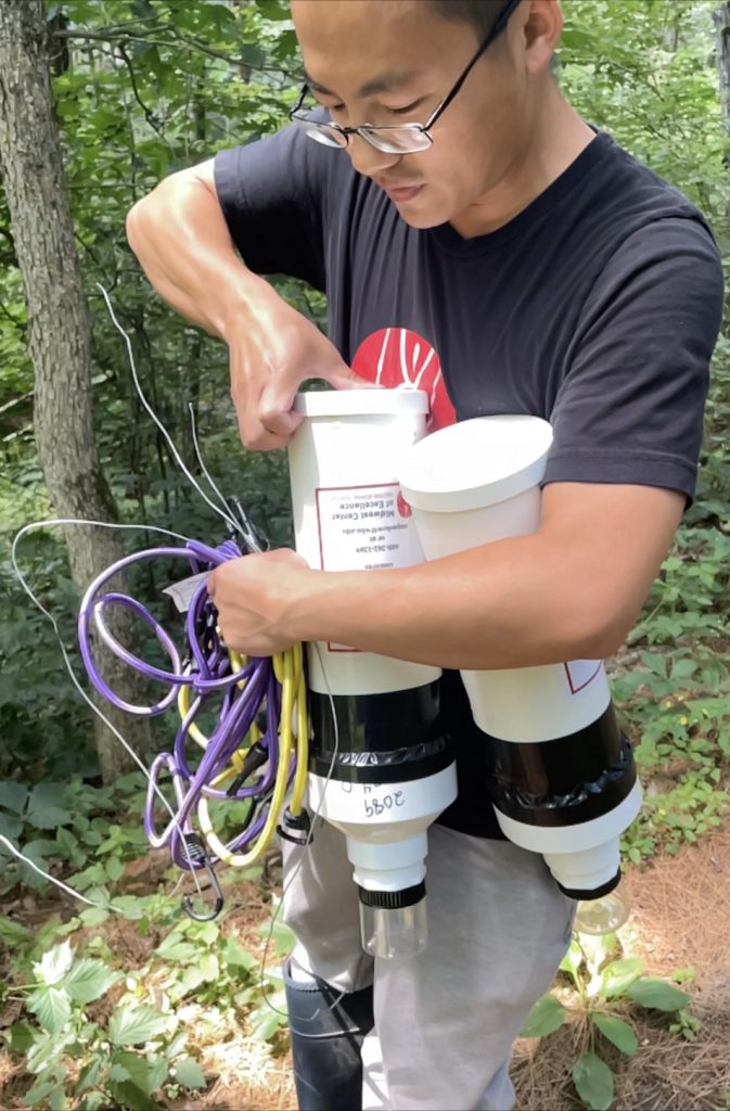 Man holding tick monitoring devices in the woods
