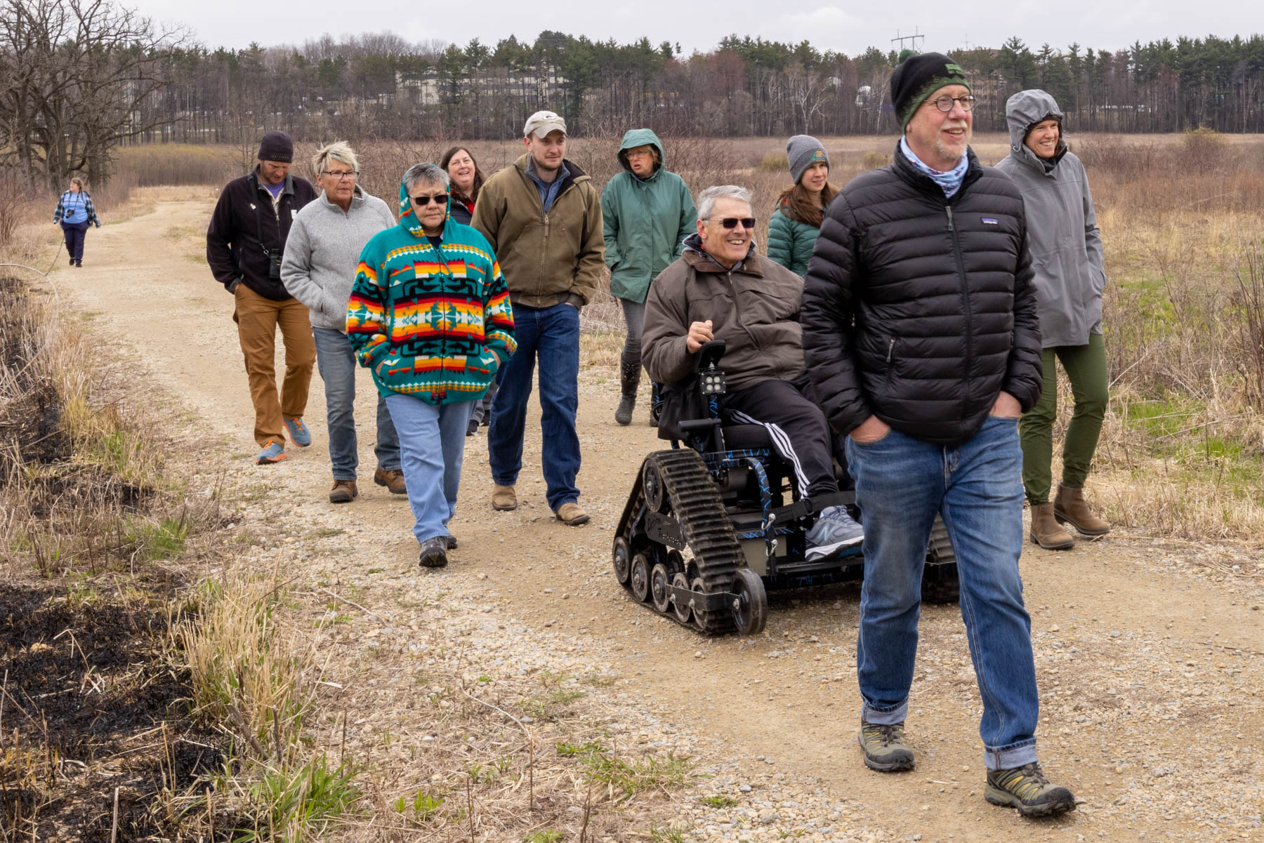 A group of Wisconsin Master Naturalists walking in a nature area. one individual is in a wheelchair.