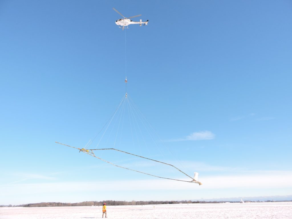 Helicopter for collecting airborne electromagnetic (AEM) data landing.