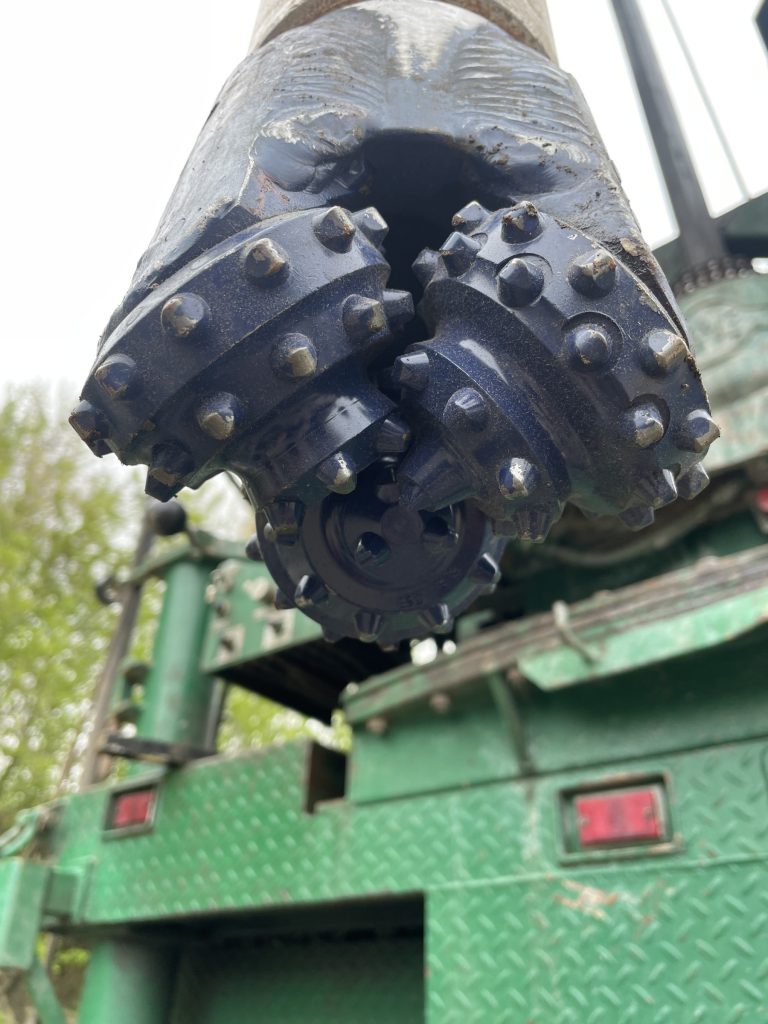 Tri-cone drill bit used for setting upper surface casing.