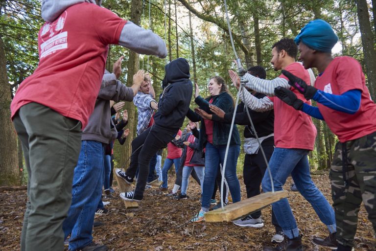 Students trying their hand at Peanut Butter Mountain, our low-element challenge course.