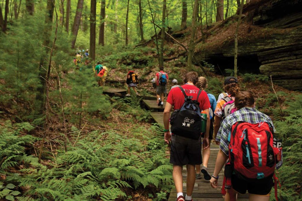 A group of kids hiking up a rocky trail