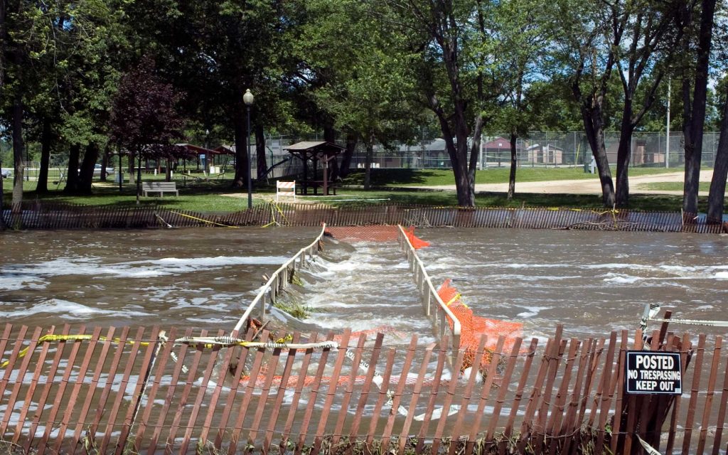 Rushing water through a park that has been fenced off for safety