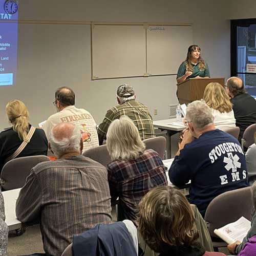 A large classroom full of woodland owners listening to a woman give a lecture