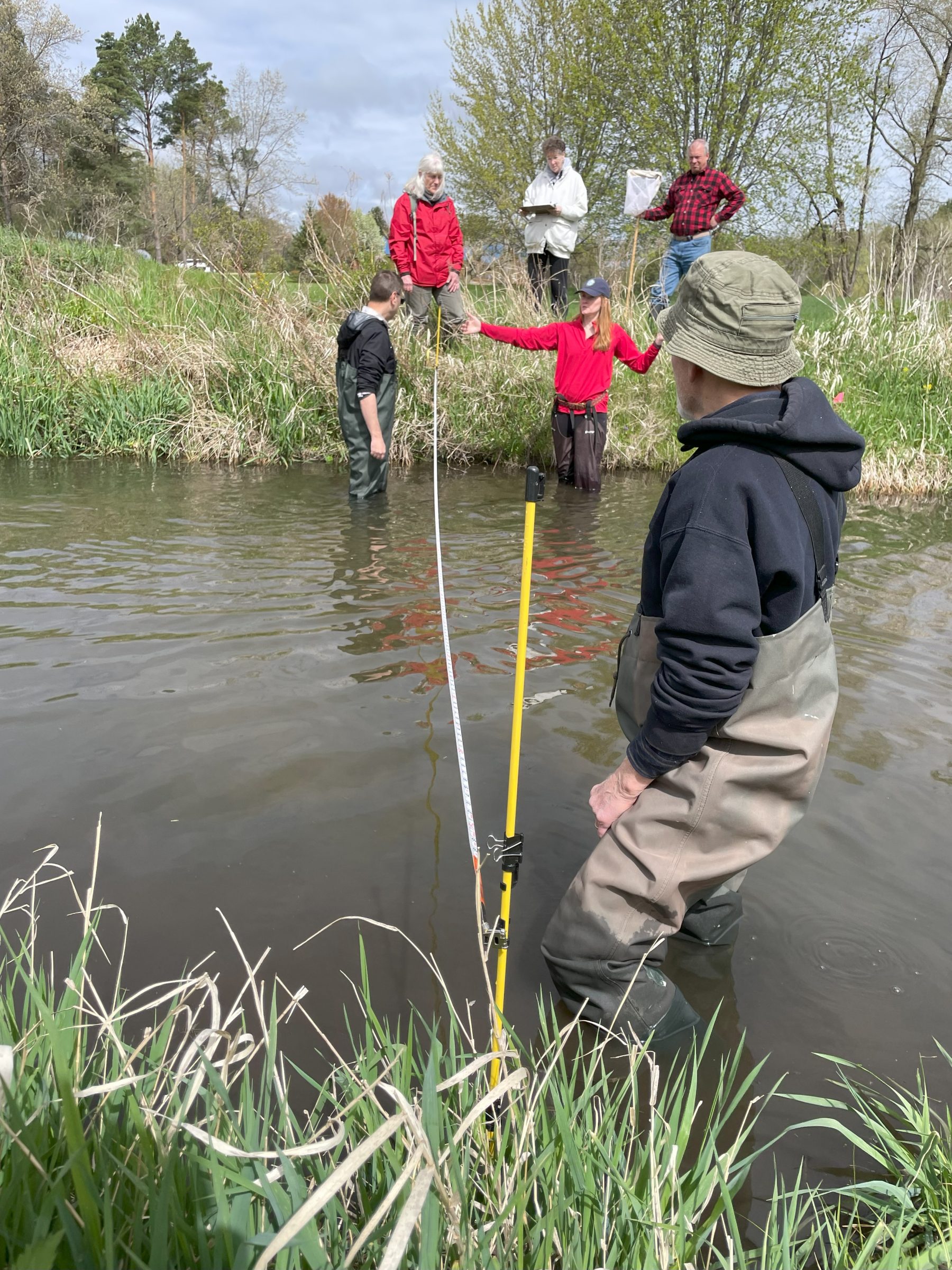 A group of people standing in a stream in Brodhead, Wisconsin for a 2025 Water Action Volunteer Training