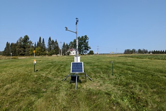 A solar powered weather station in a grass field