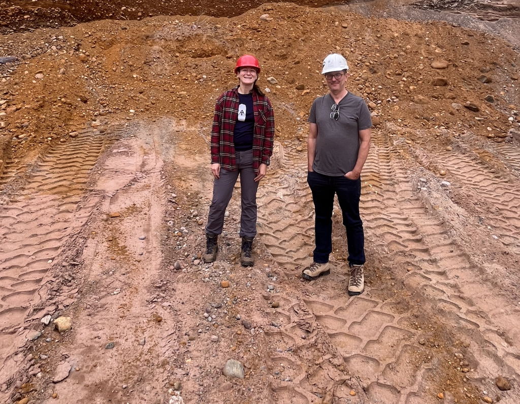 Amy Wiersma and Elmo Rawling standing in a quarry with hard hats on.