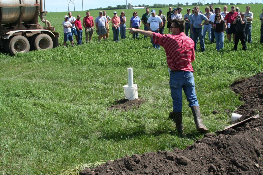 Kevin Erib, CPTP Program Manager demonstration a manure spill to a group of farmers in the field.