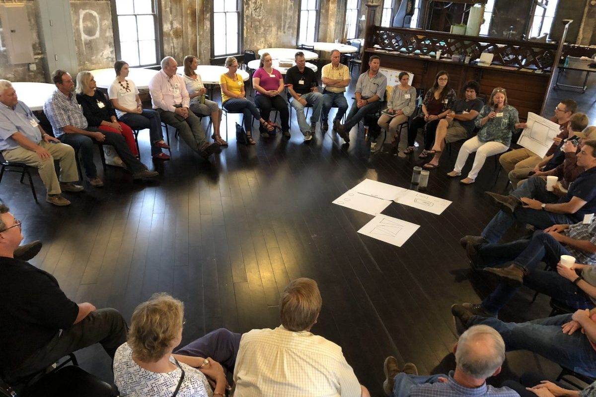 People sitting in a circle in a large room
